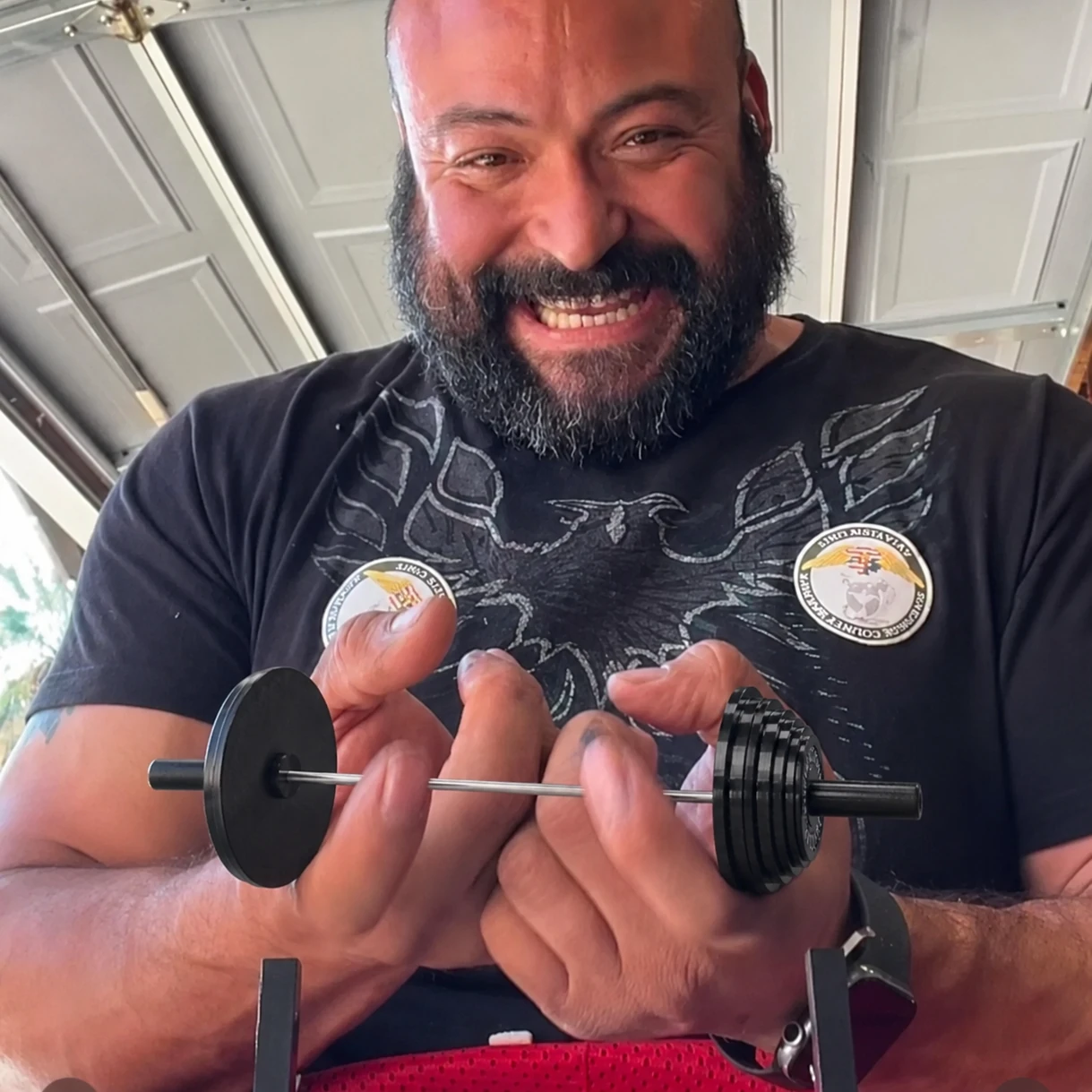 Customer holding a miniature barbell with black weight plates in both hands