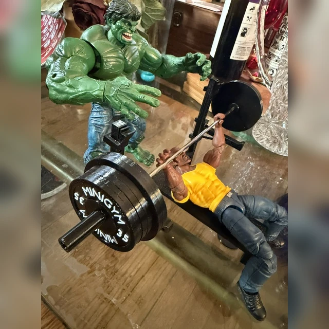 Customer photo of two action figures with a miniature bench press and loaded barbell